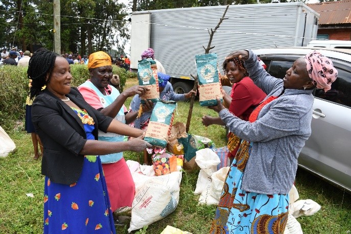 Farmers showcasing packets of certified maize seeds received from the County for planting